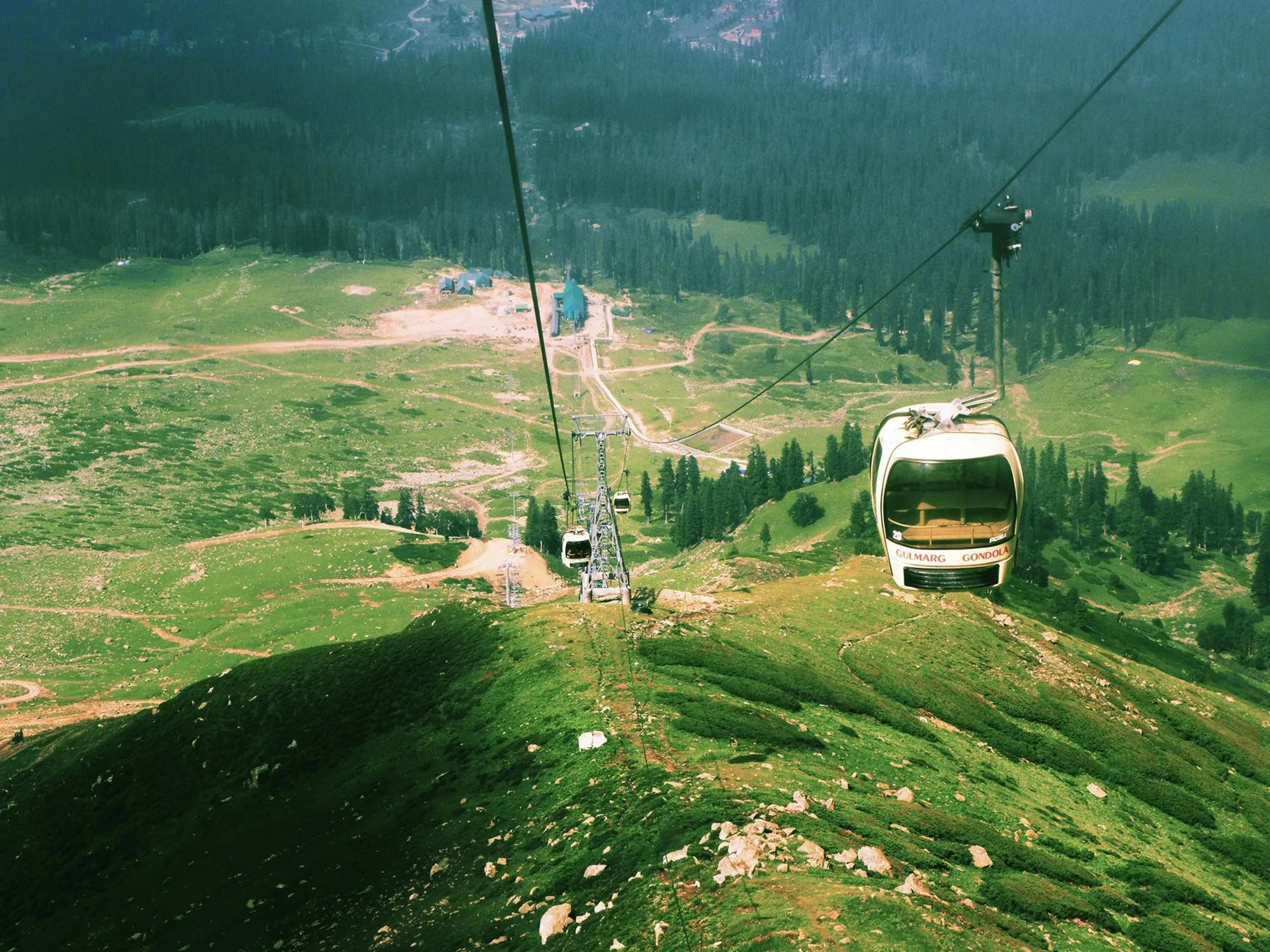 The Gulmarg gondola rising over green slopes