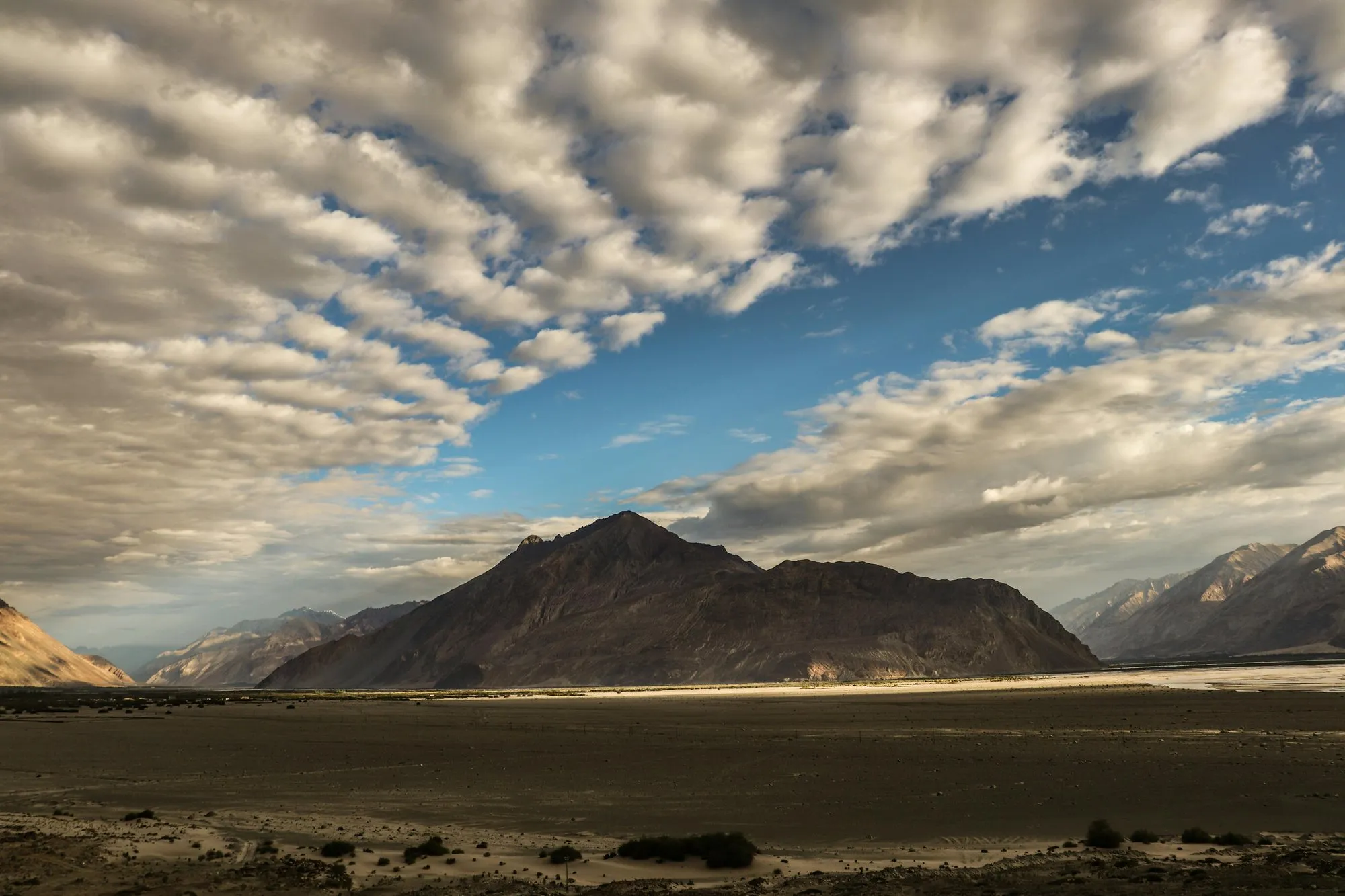 Clouds streaming over a wide mountain plain