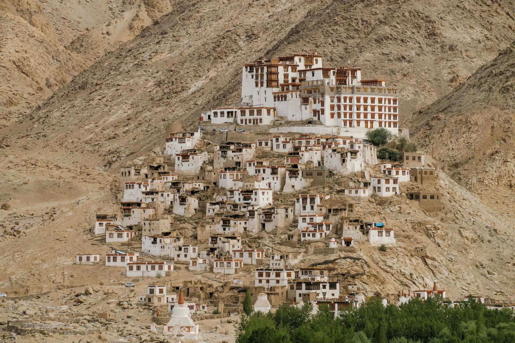 A monastery village spread down a bare hillside