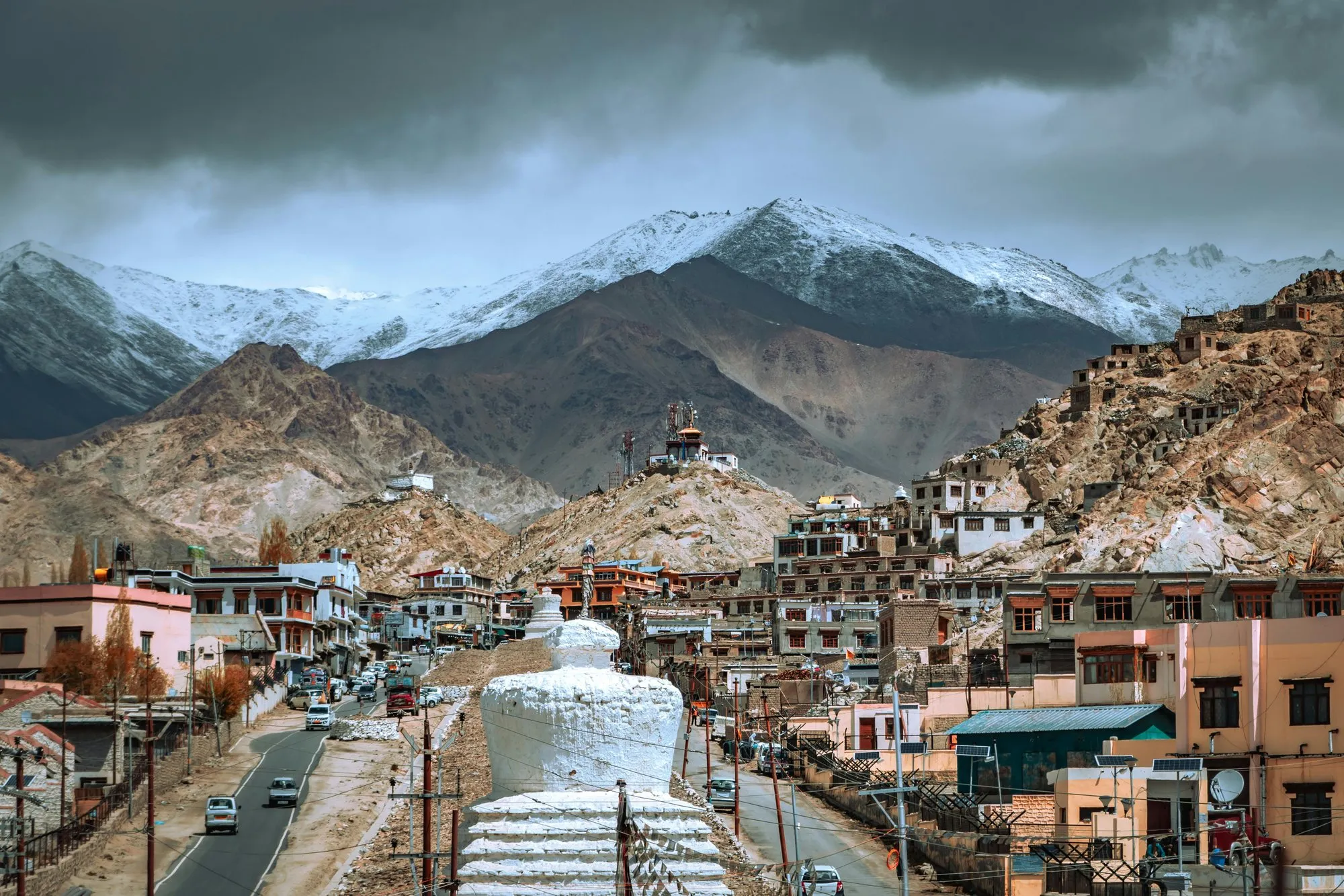 Leh’s main road below a white stupa and snow peaks