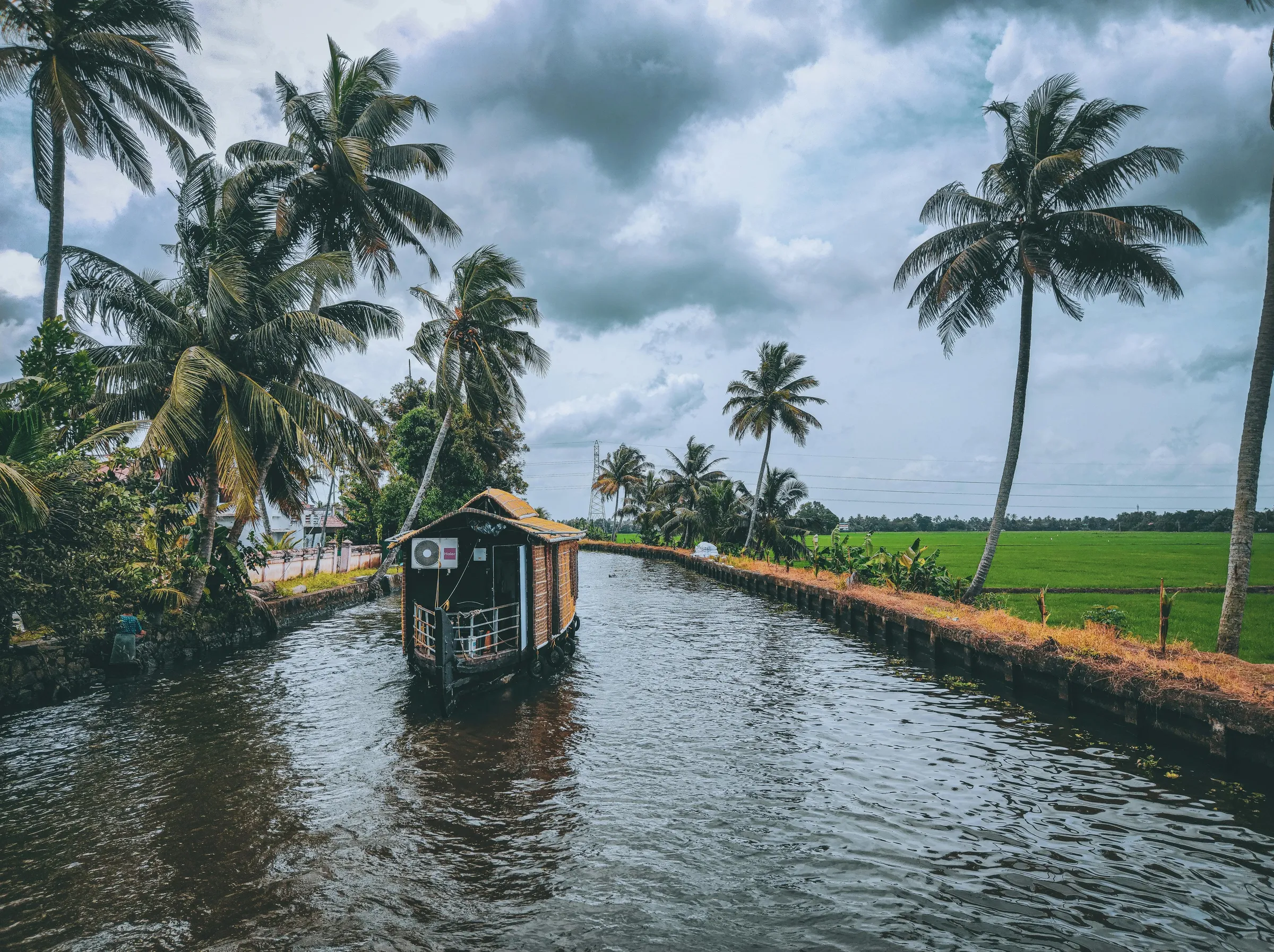 A houseboat on a palm-lined canal in the Kerala backwaters