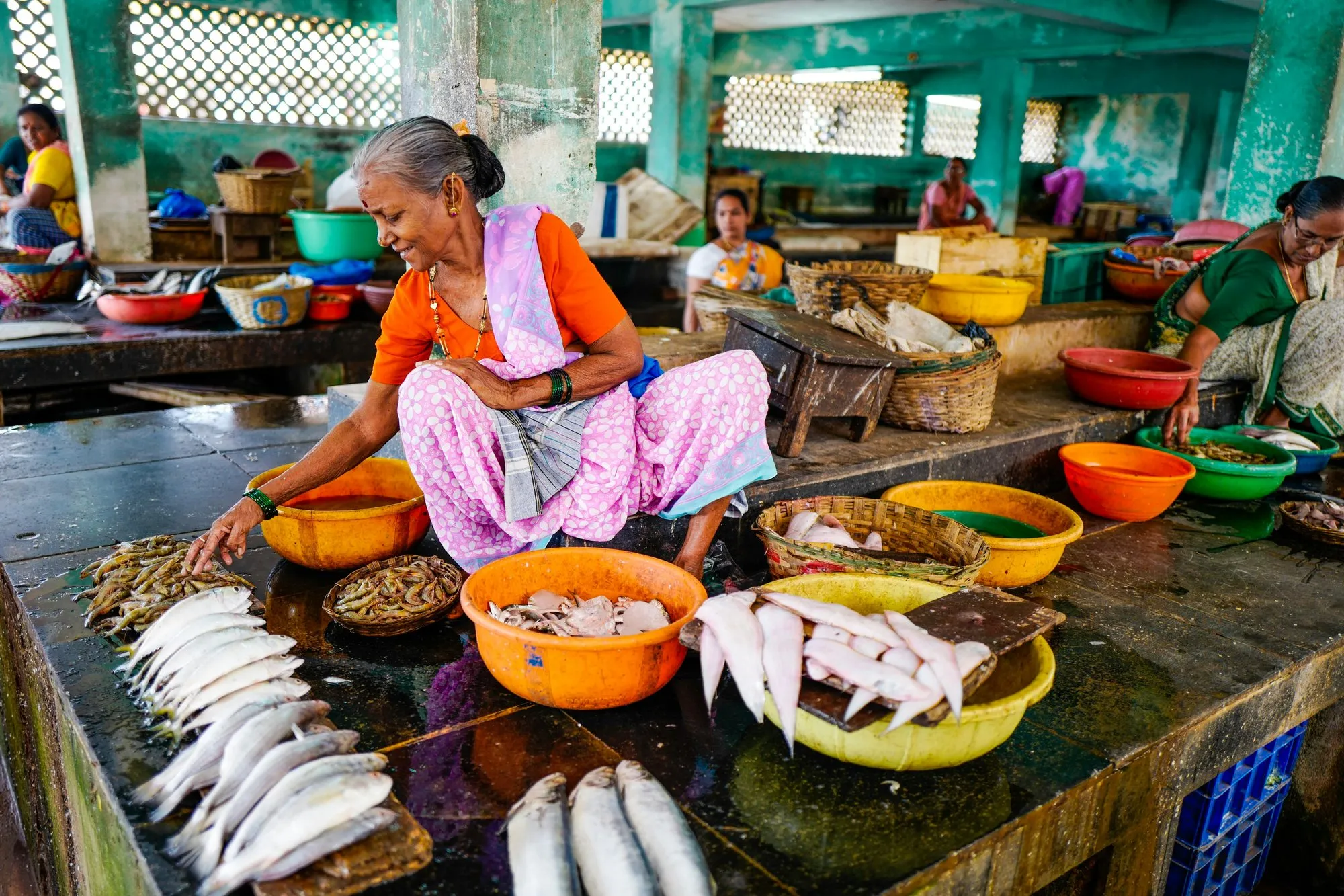 A woman selling fish at a busy market