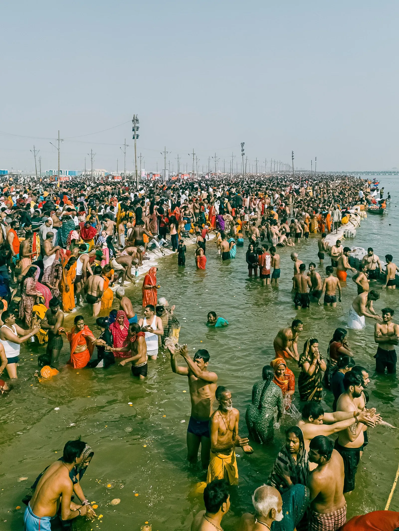Pilgrims bathing waist-deep at the confluence, Prayagraj