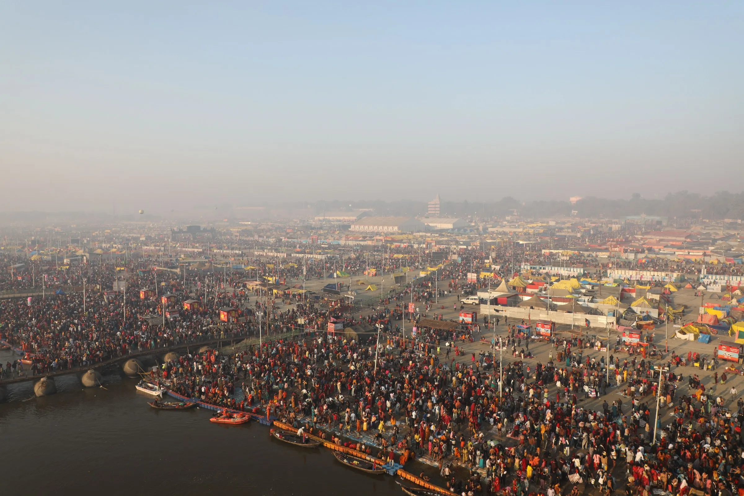 The tent city of the Kumbh spread across the floodplain at dusk, Prayagraj