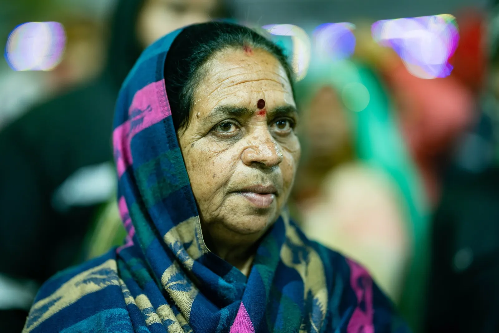 An elderly woman pilgrim in a patterned shawl at the Mela, Prayagraj