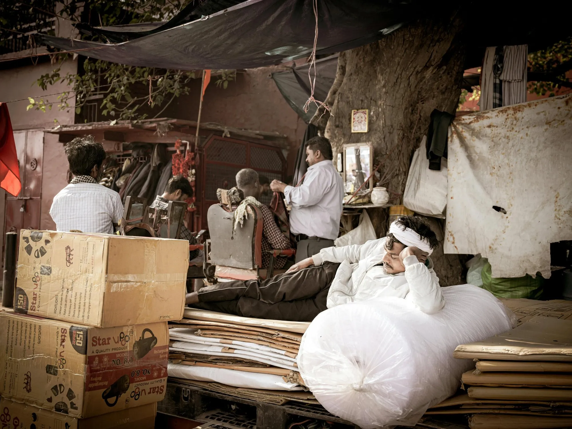 A trader resting on a bale in an Old Delhi market