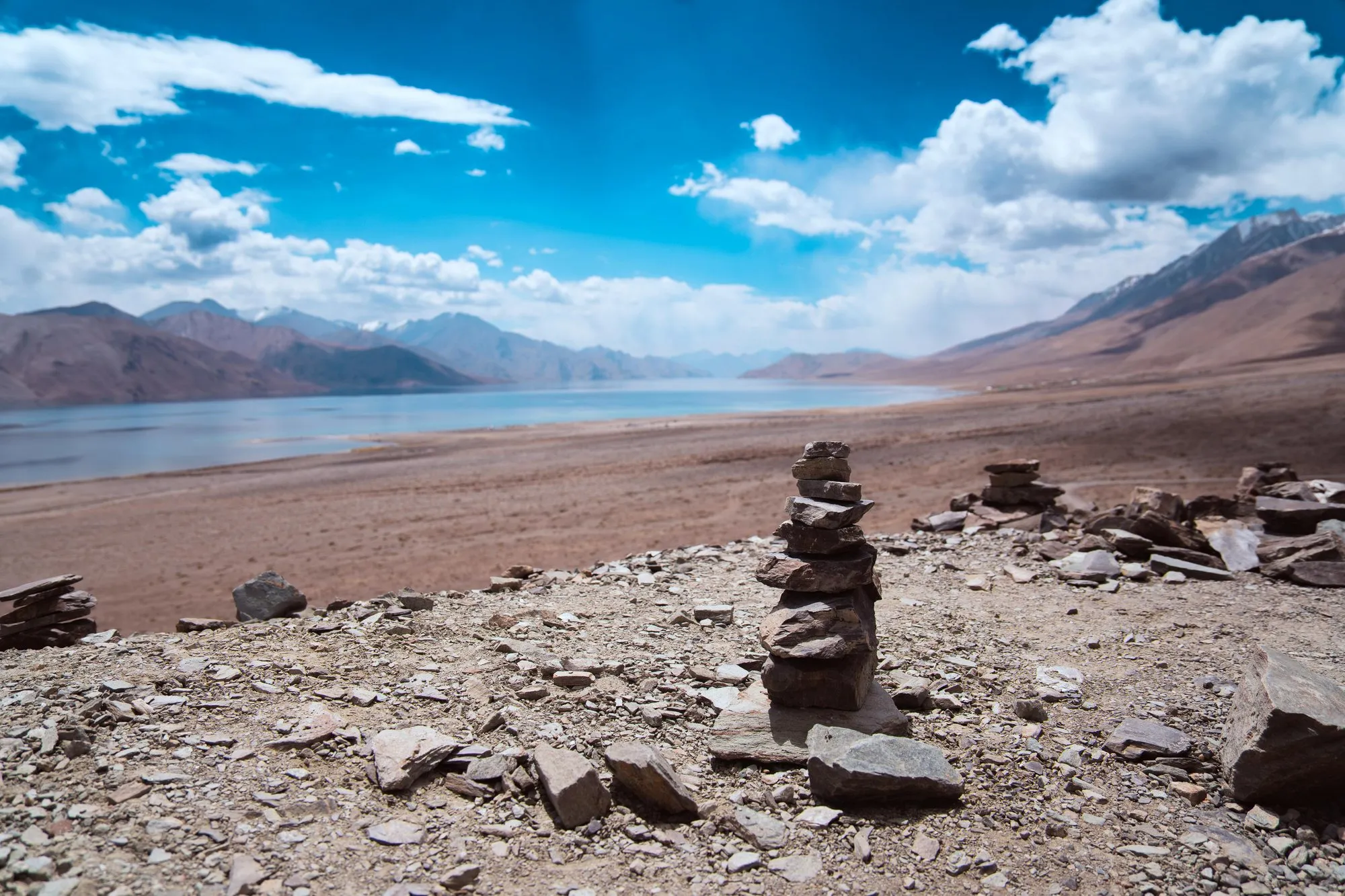A stone cairn above the shore of a high lake