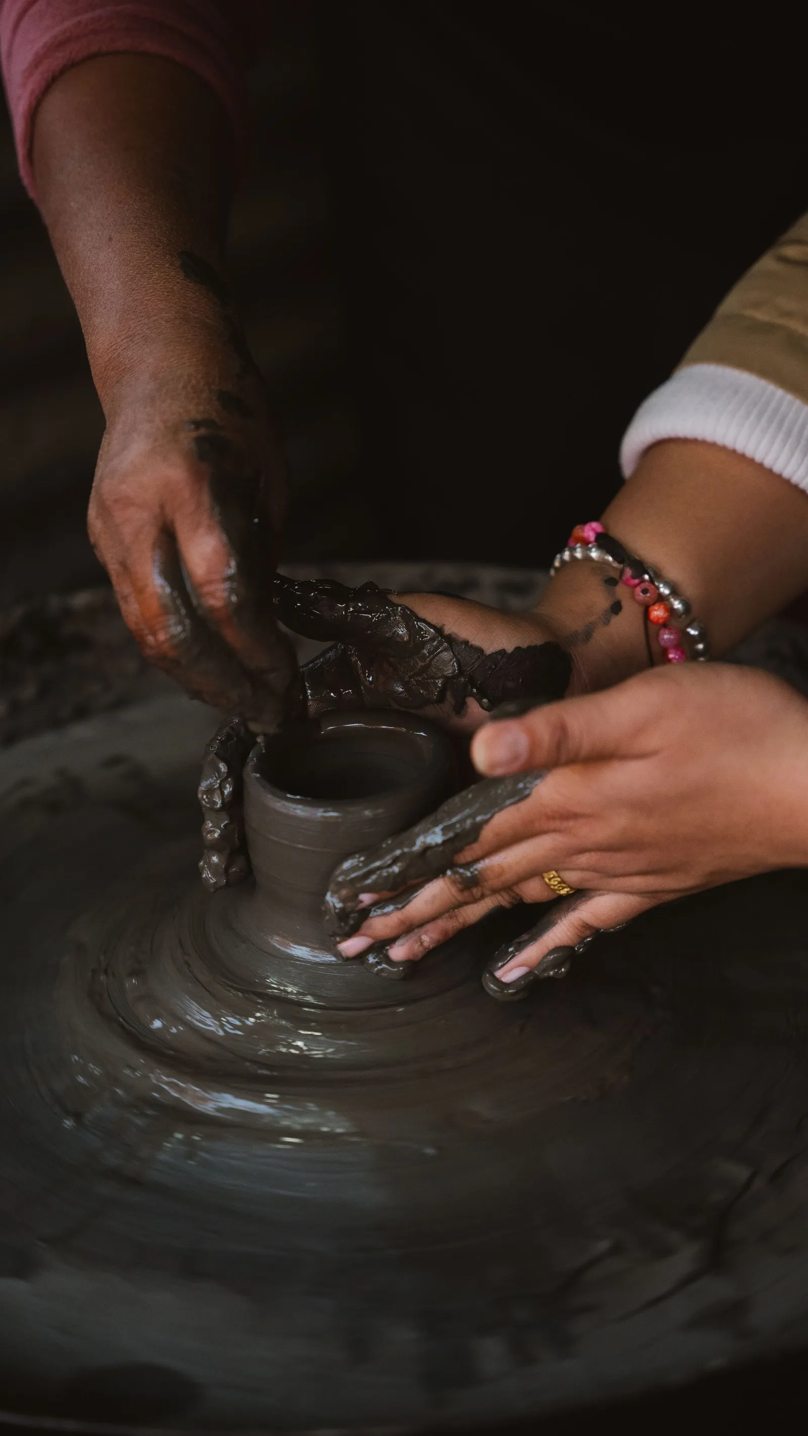 Hands shaping a pot on the wheel in Bhaktapur