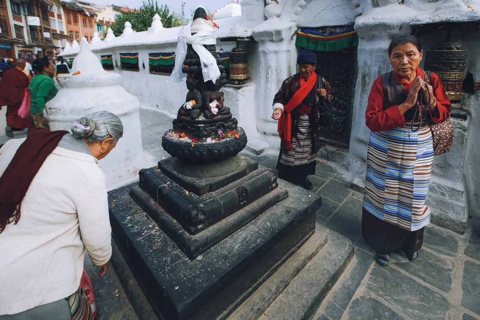 Tibetan women at prayer beside a shrine at Boudhanath