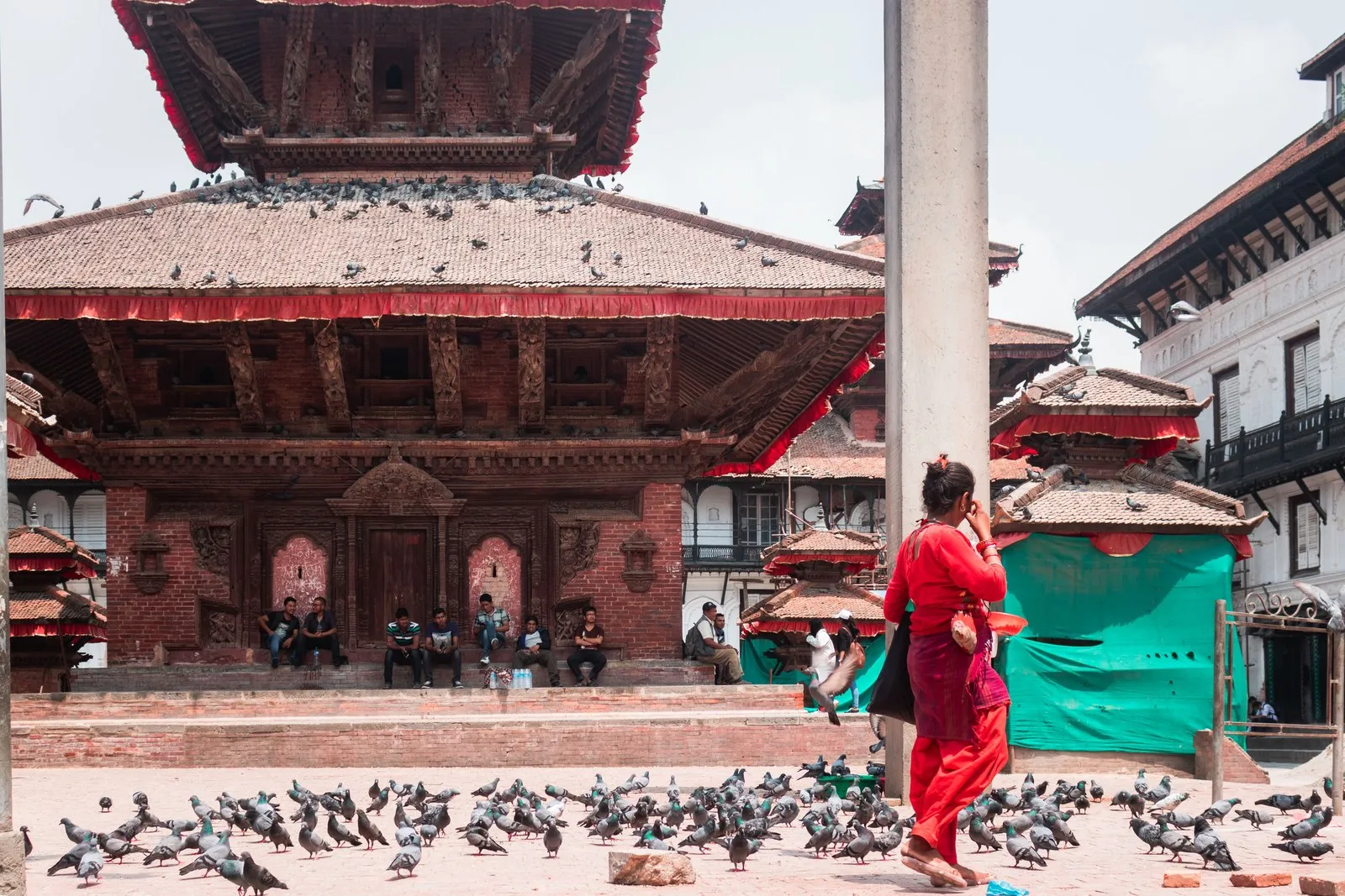 A woman in red among the pigeons in Kathmandu Durbar Square