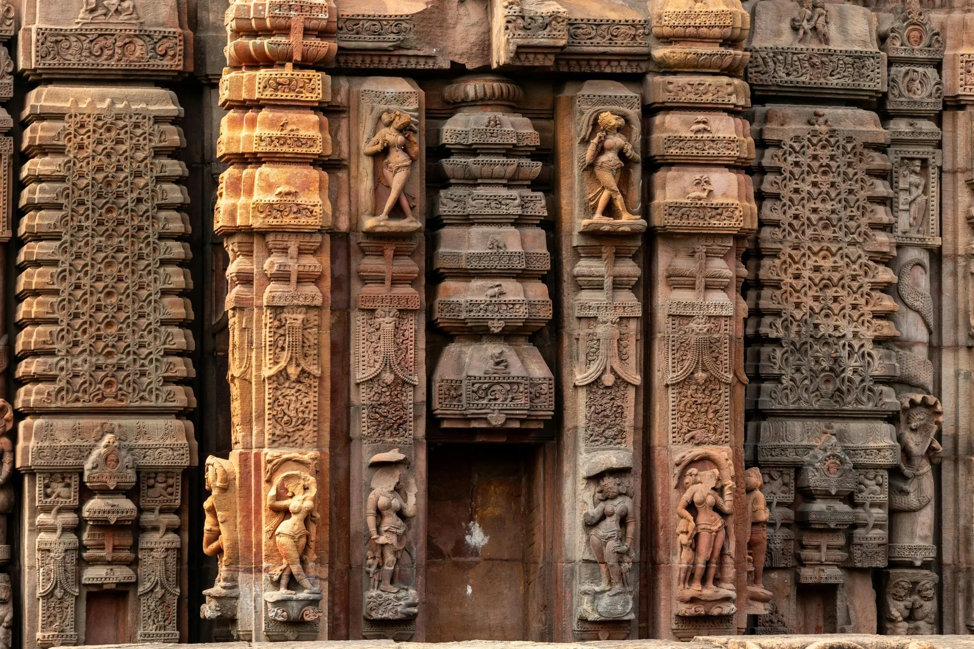A carved sandstone temple wall of niches and figures