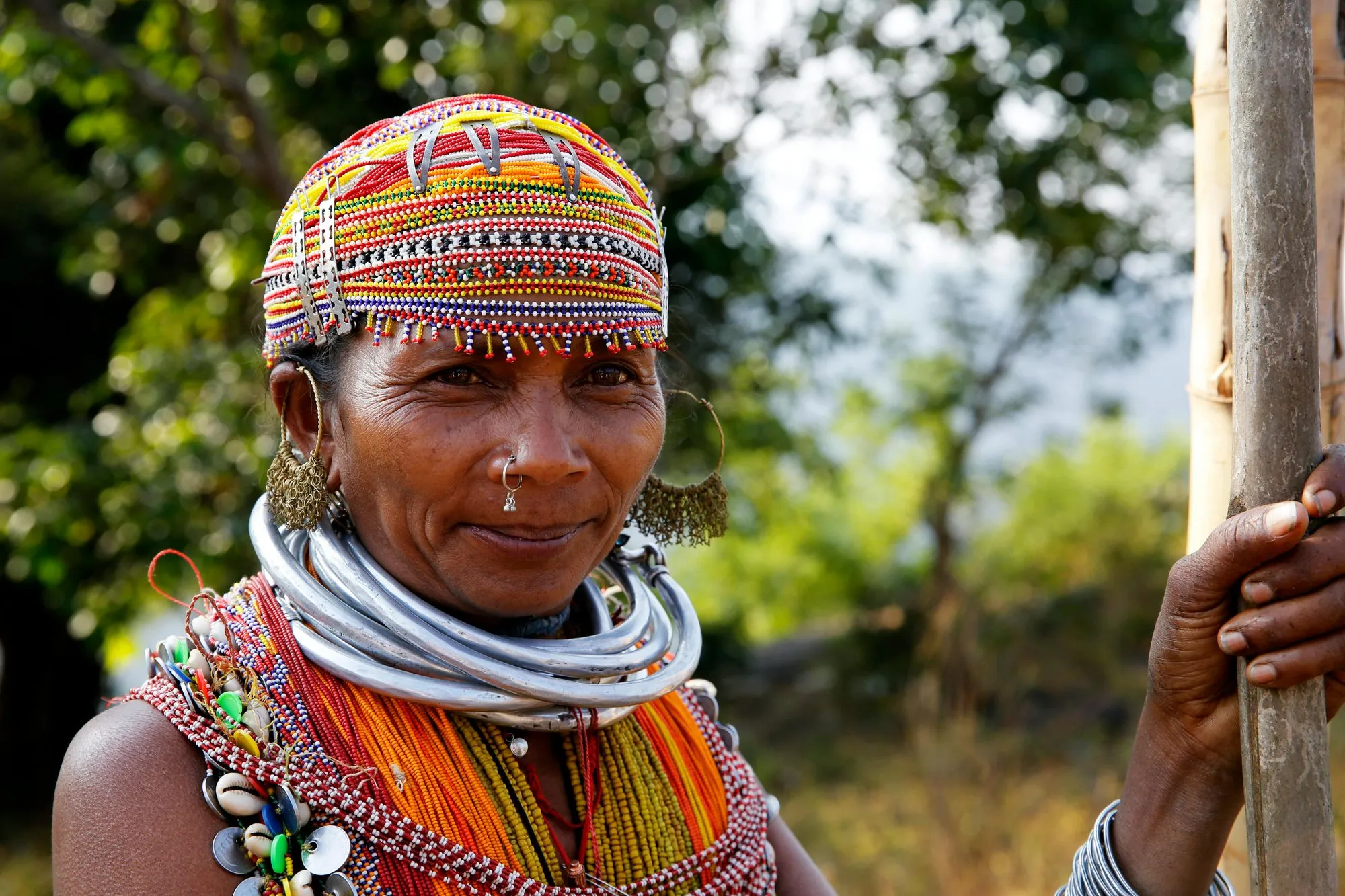 A woman in a beaded cap, bead necklaces and a silver neck ring