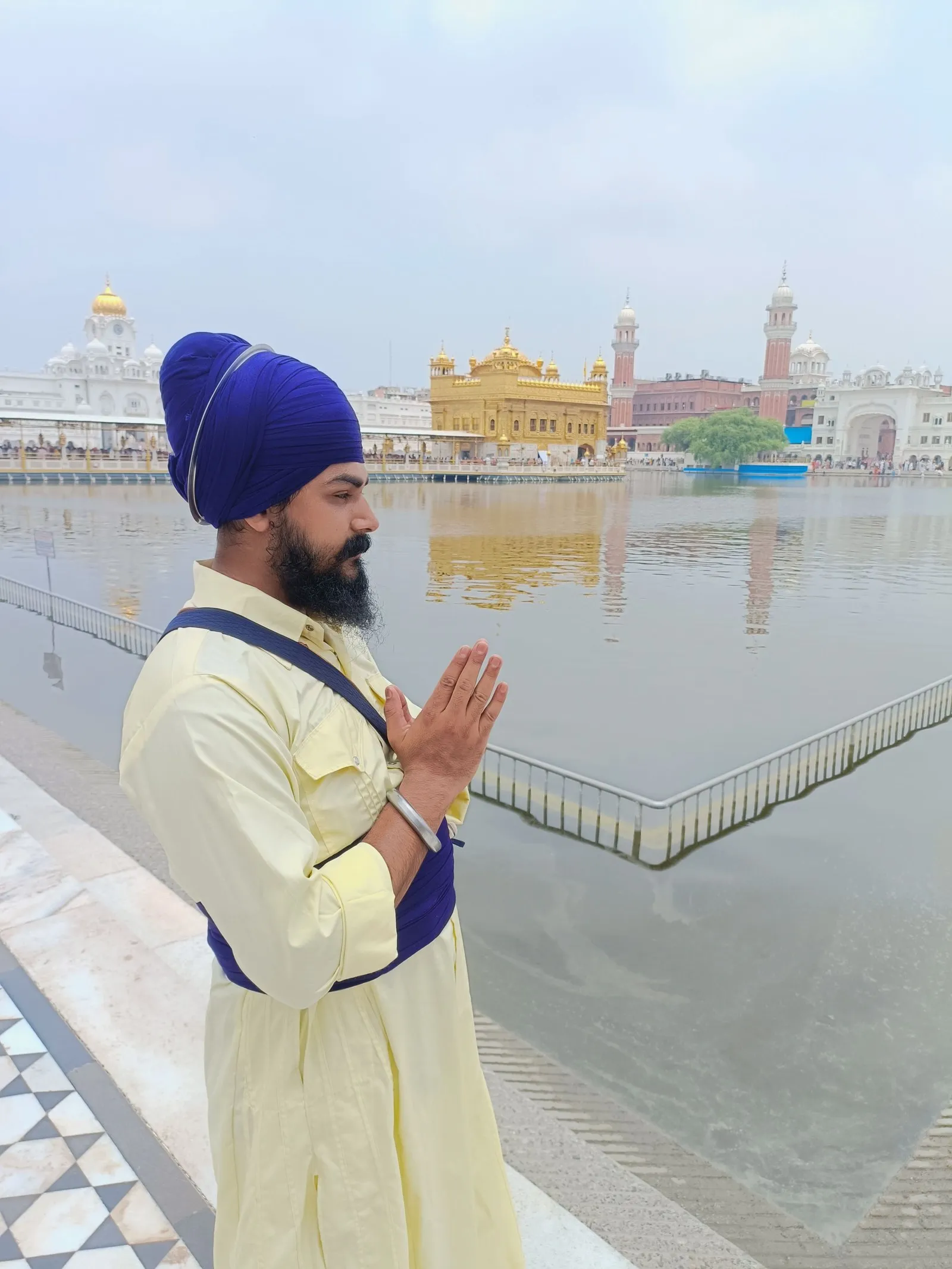 A Sikh pilgrim with joined palms beside the sacred pool of the Golden Temple, Amritsar