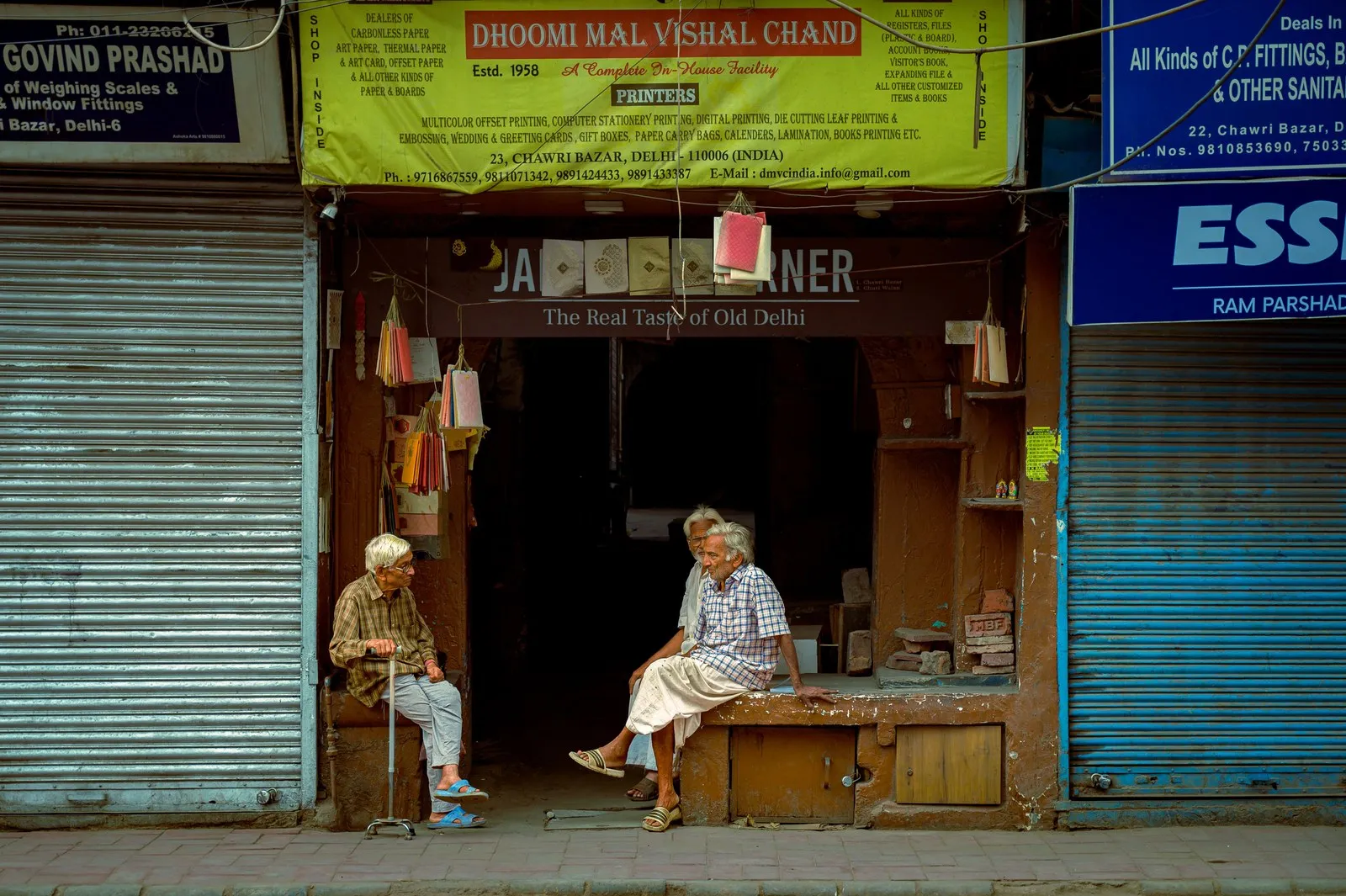 Two elderly men talking outside their shop in Old Delhi