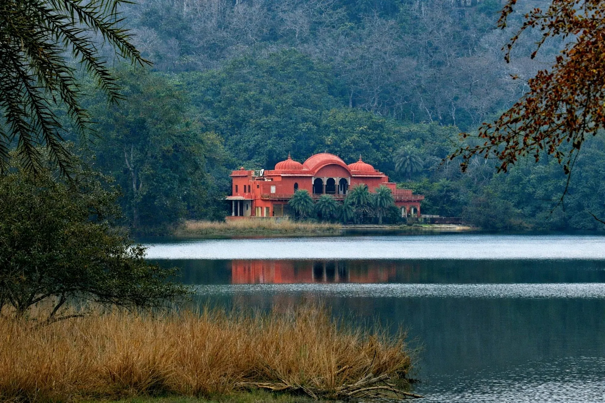 A red palace on a forest lake