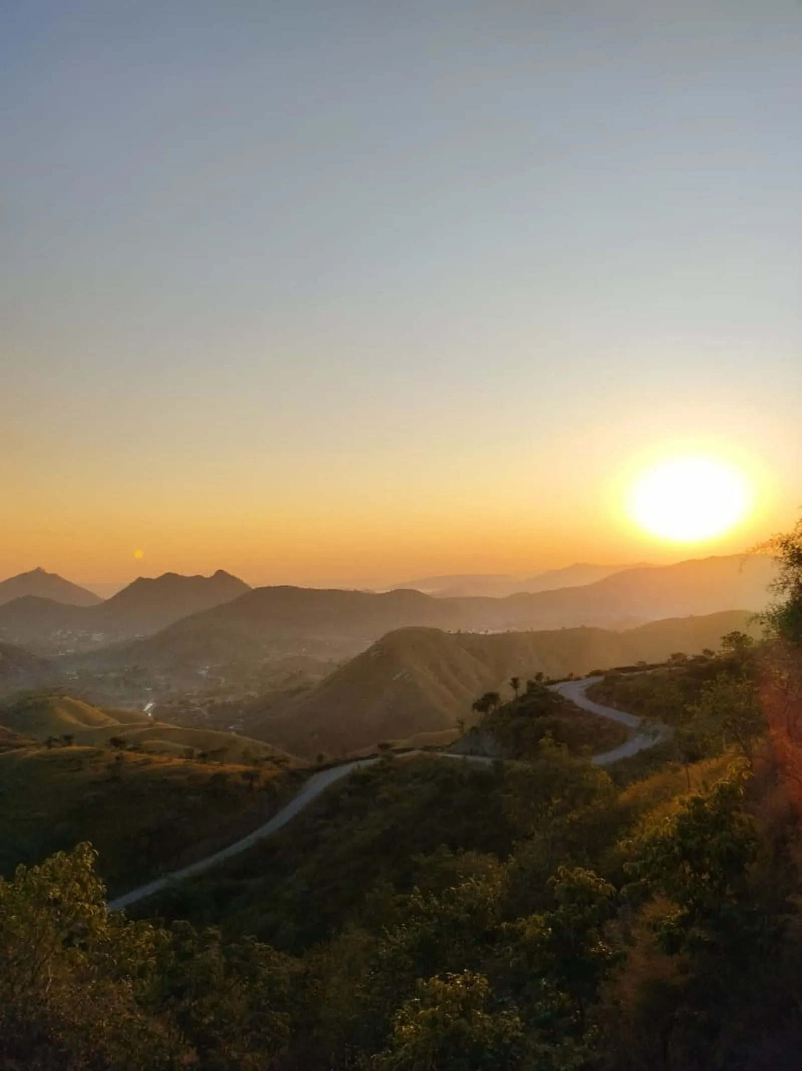 A road winding into the Aravalli hills at sunset, near Udaipur