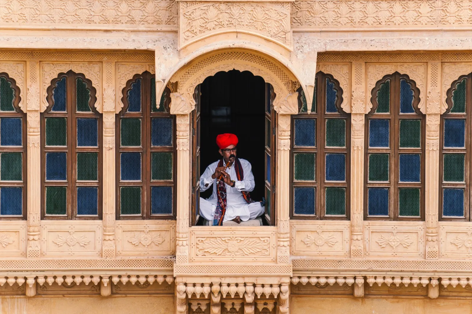 A musician playing the algoza in a carved sandstone window, Jaisalmer