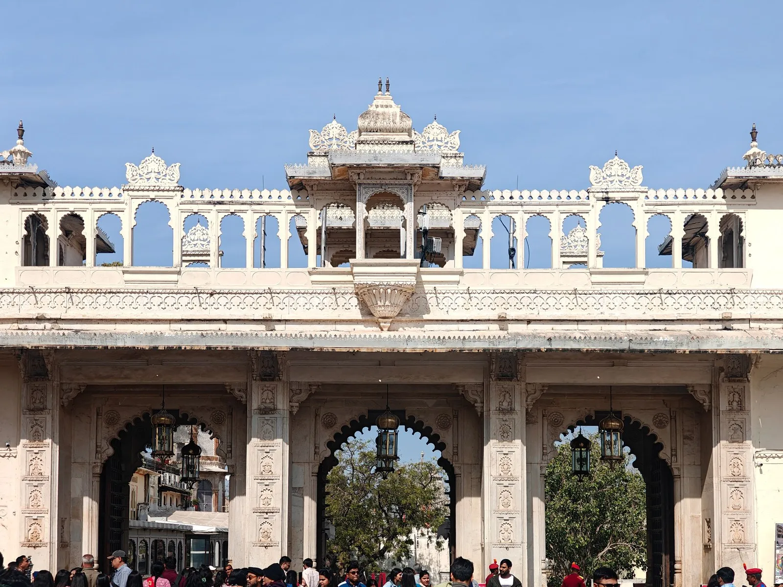Visitors under the carved gateway of the City Palace, Udaipur