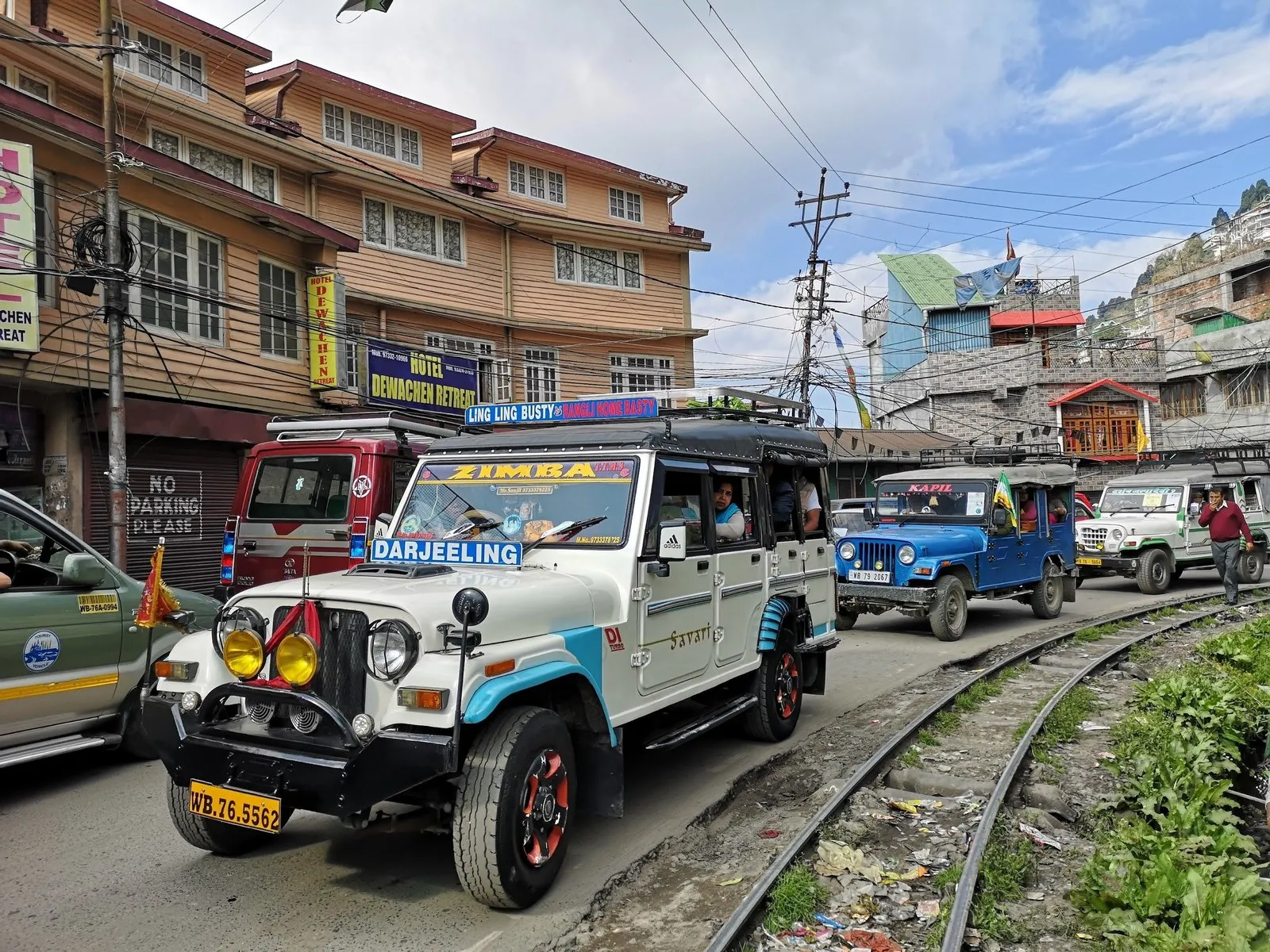 Shared jeeps on a Darjeeling street beside the narrow-gauge line of the toy train
