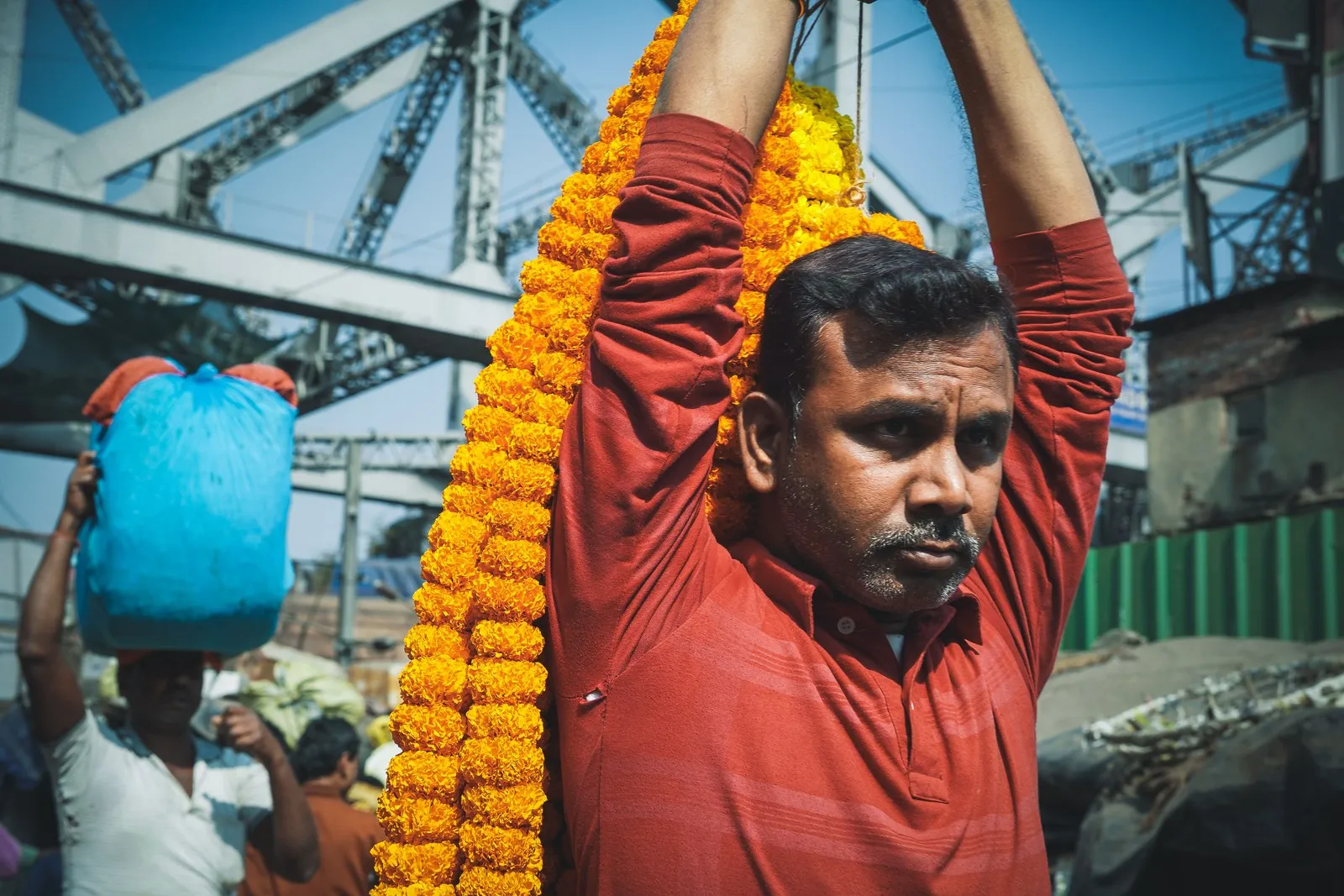 A garland seller with marigolds under the girders of Howrah Bridge, Kolkata