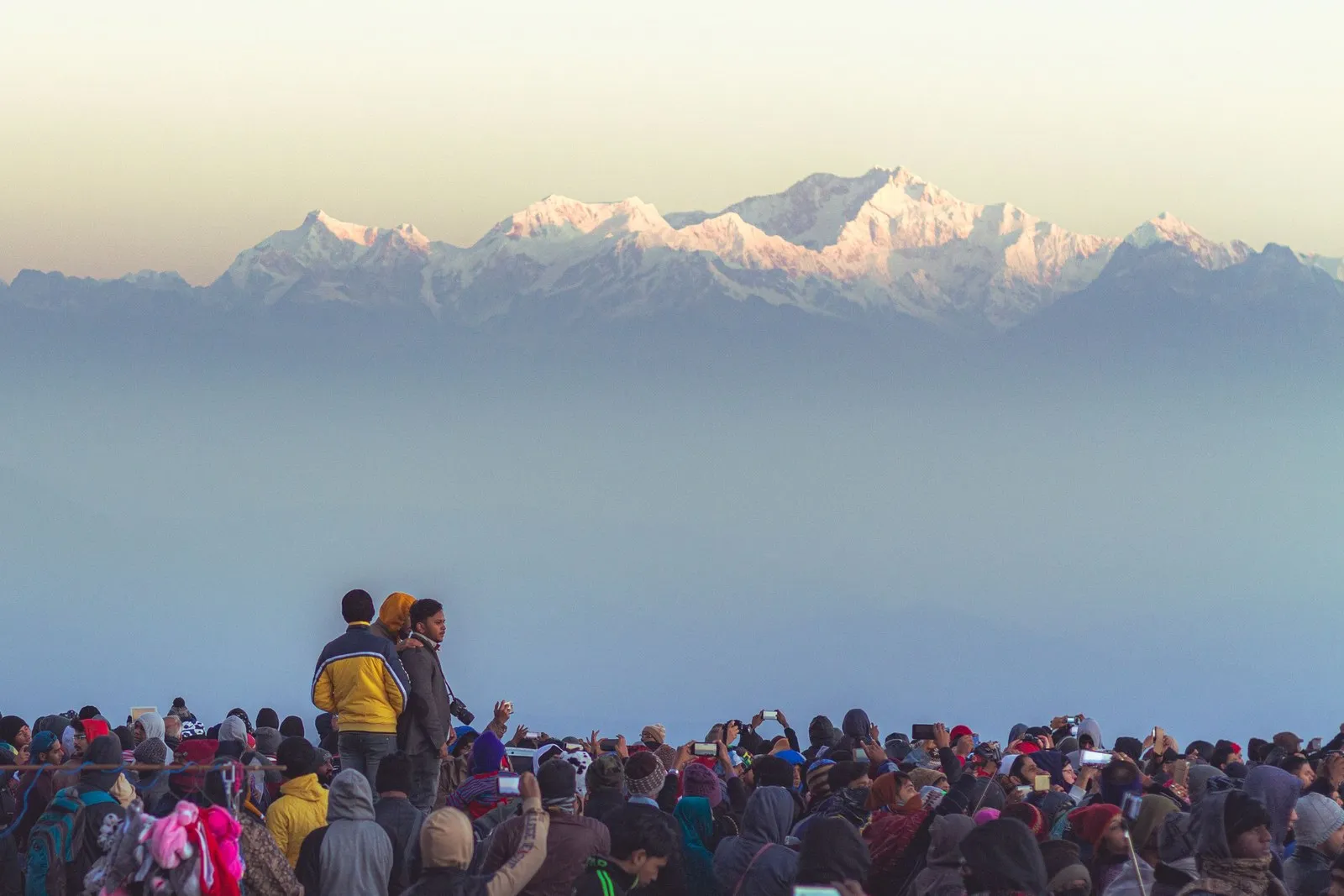 A crowd in woollens waiting at dawn as the first light reaches Kanchenjunga