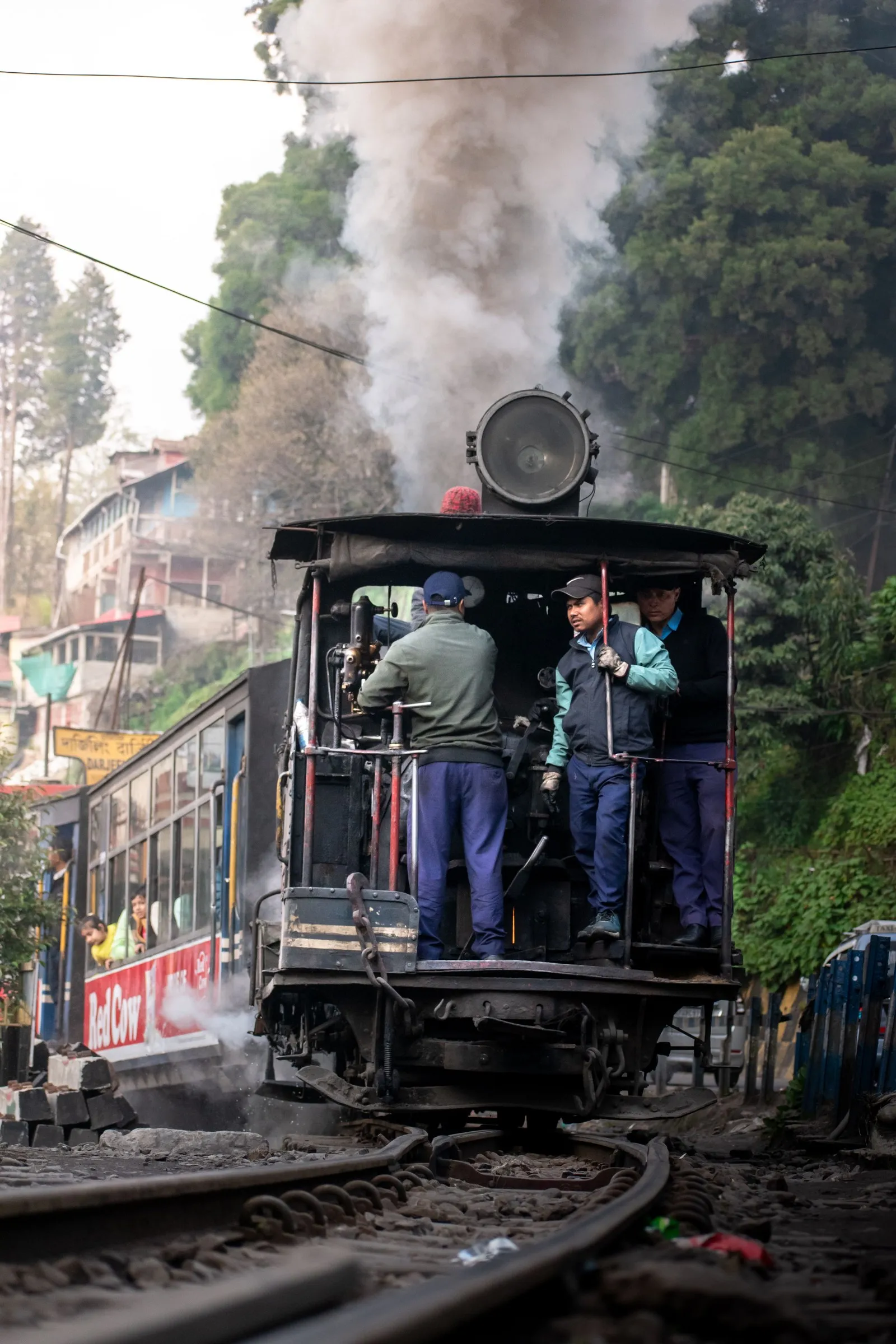 The crew on the footplate of a Darjeeling Himalayan Railway steam engine, smoke rising
