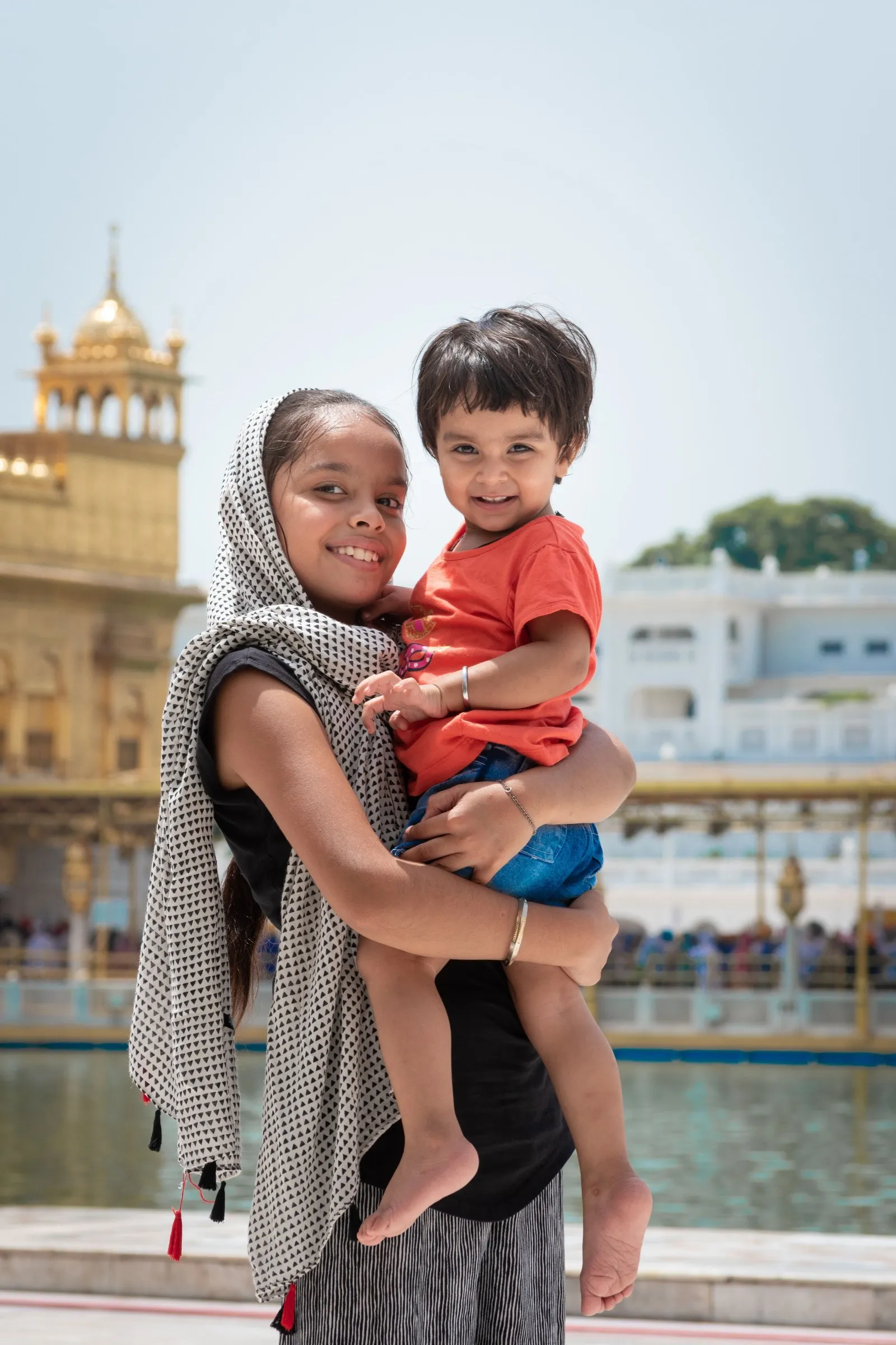 A young woman carrying a small boy by the Golden Temple, Amritsar
