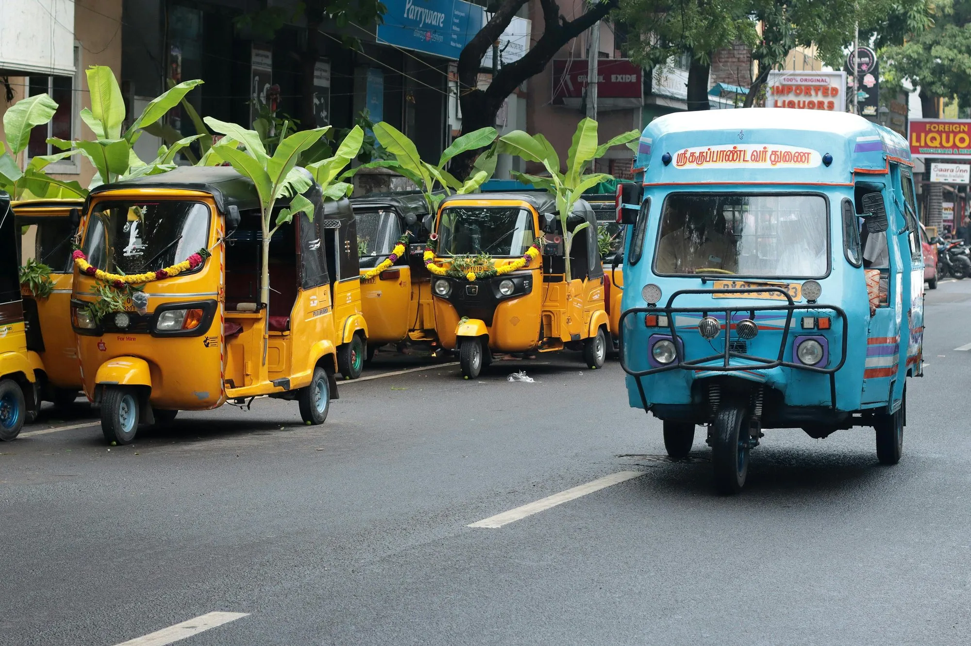 Yellow and blue autorickshaws on a street