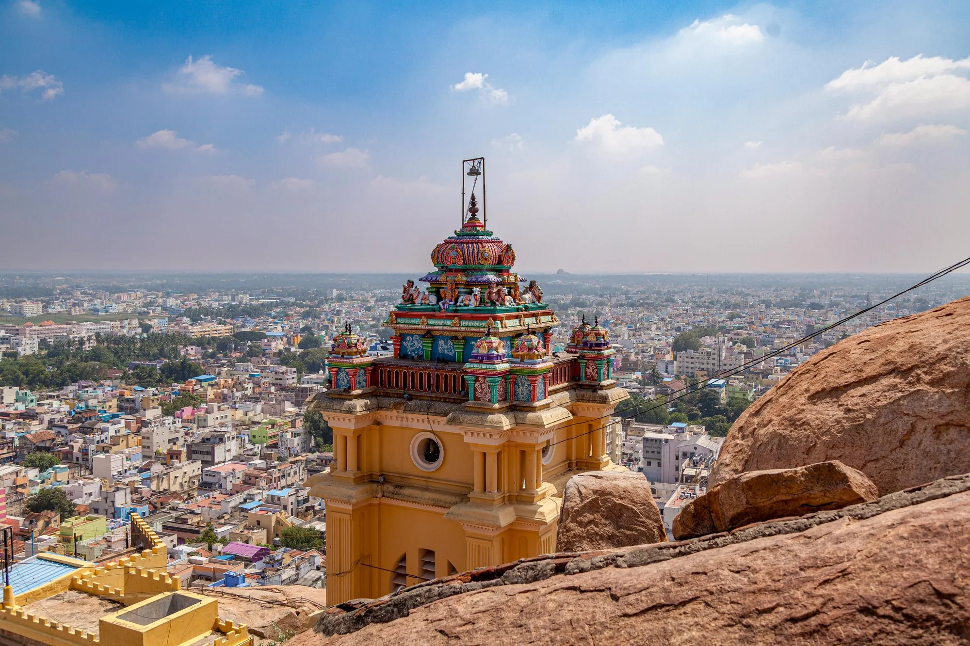 A temple tower above a city seen from a rock