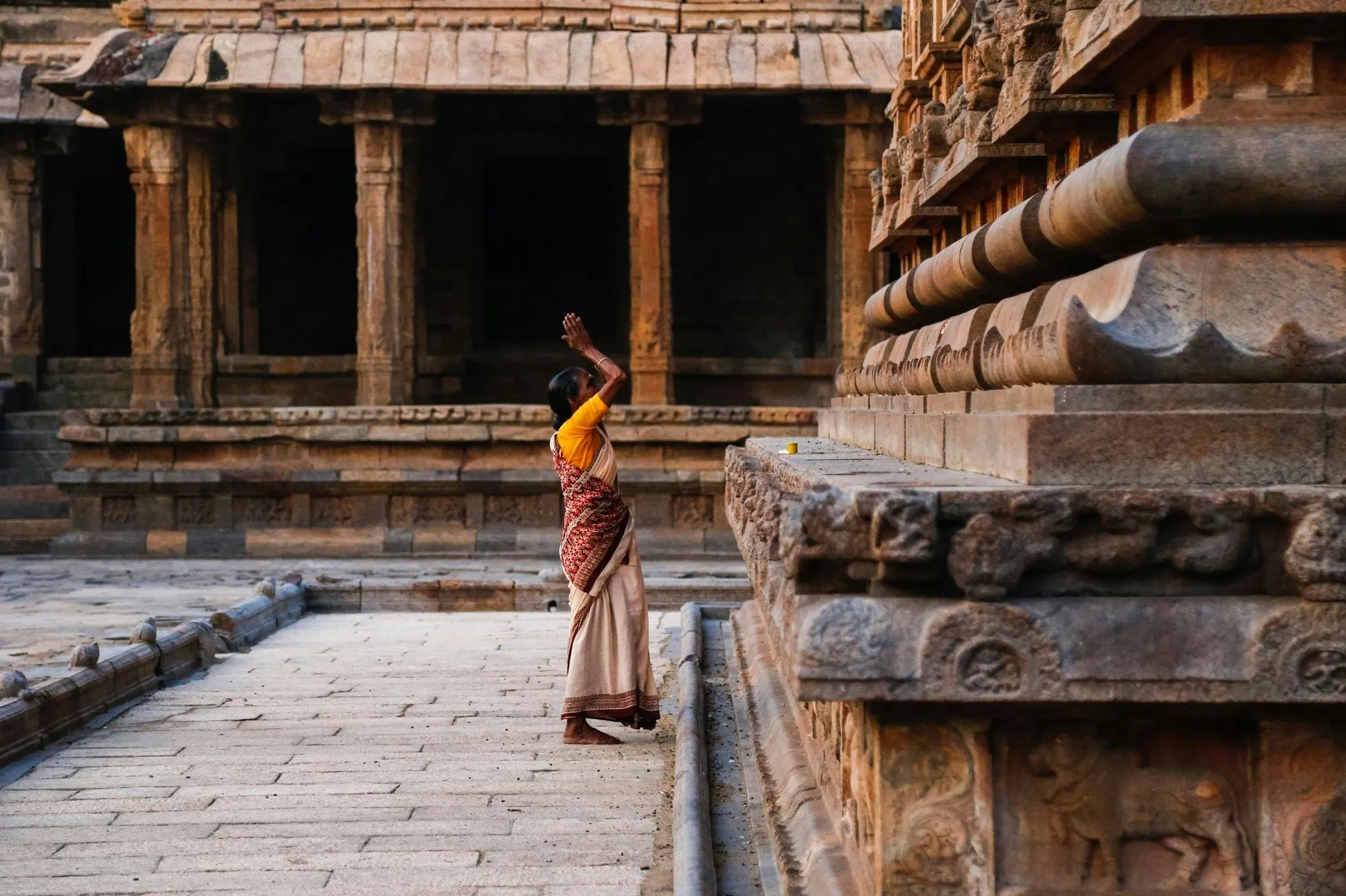 A woman praying at a temple tank
