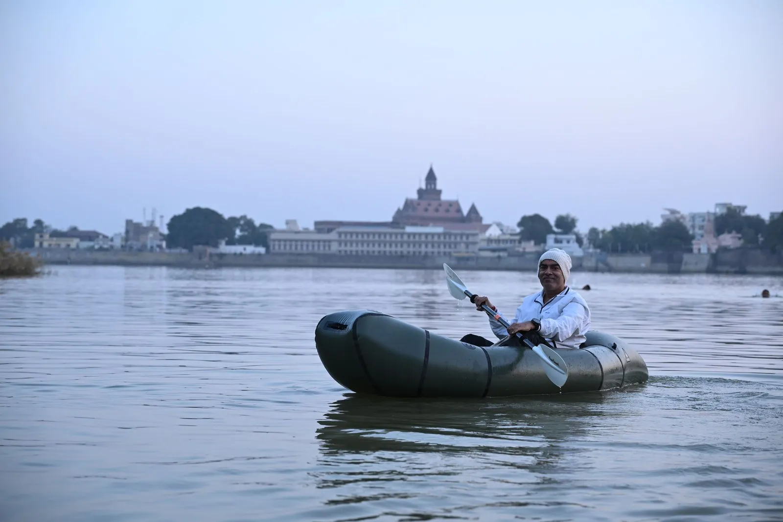 A man paddling on Hamirsar Lake below the old city of Bhuj
