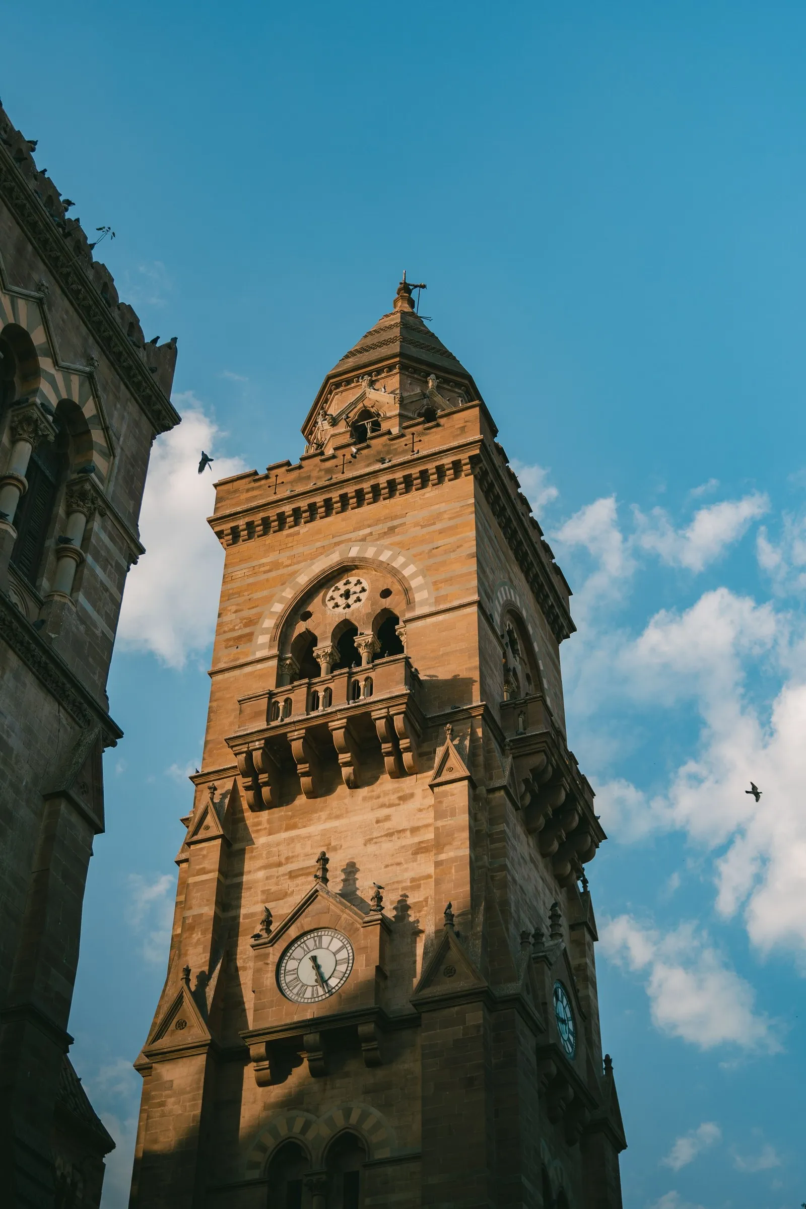 The clock tower of the Prag Mahal against a blue sky, Bhuj