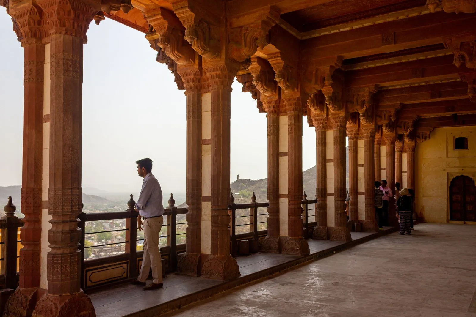 A visitor looking out from a colonnaded terrace of Amber Fort, near Jaipur