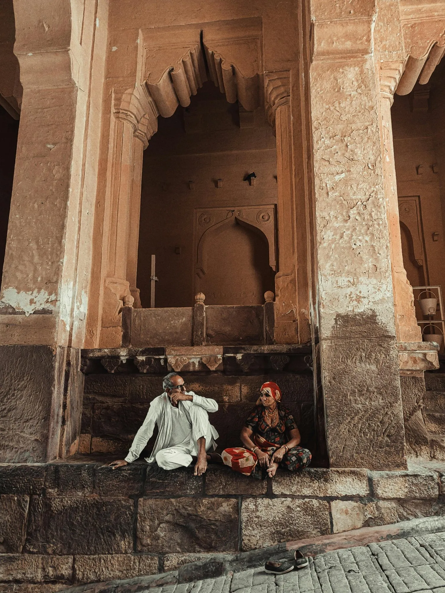 Two men seated in a sandstone alcove