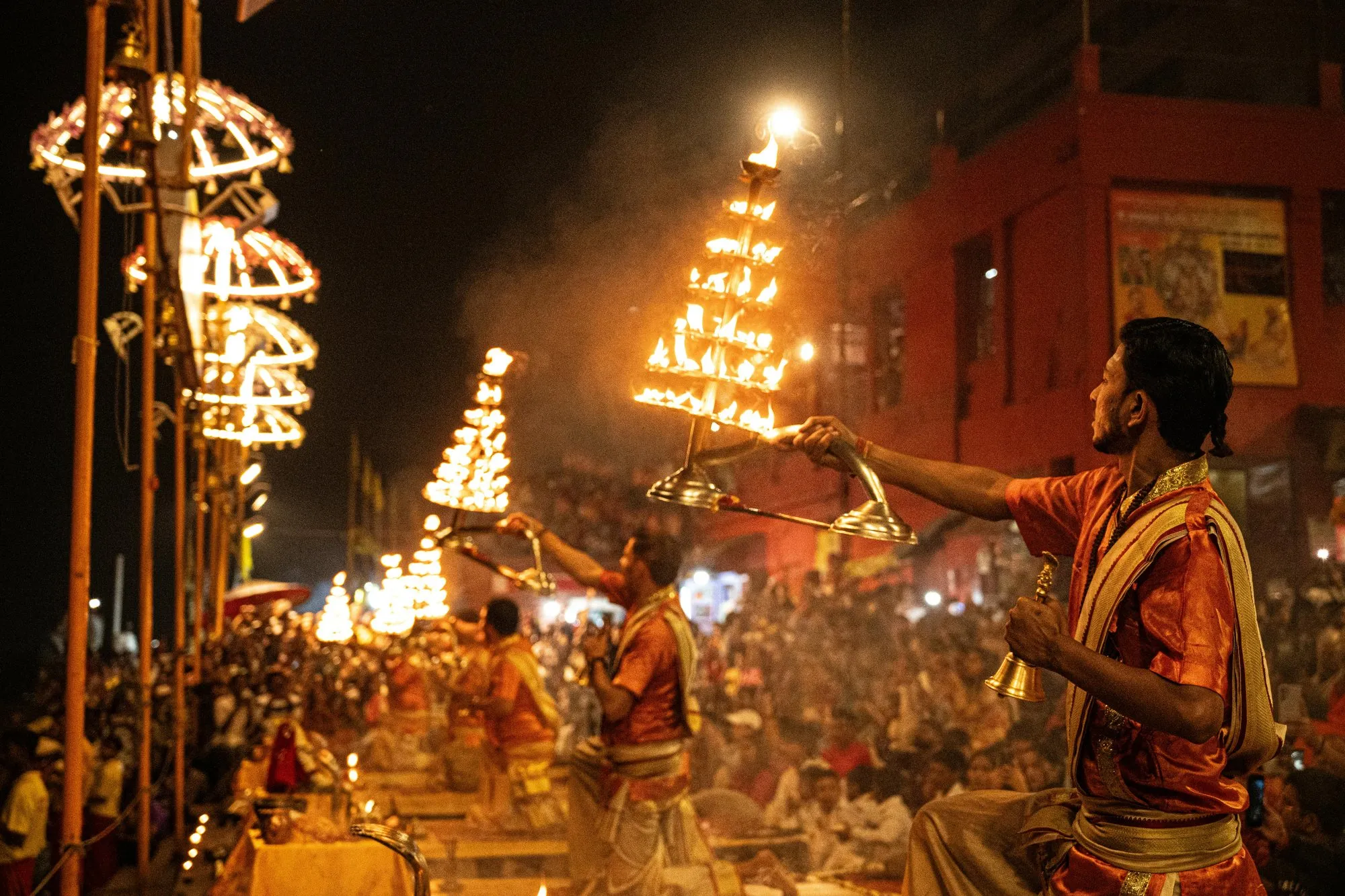 Priests raising tiered lamps at the Ganga Aarti
