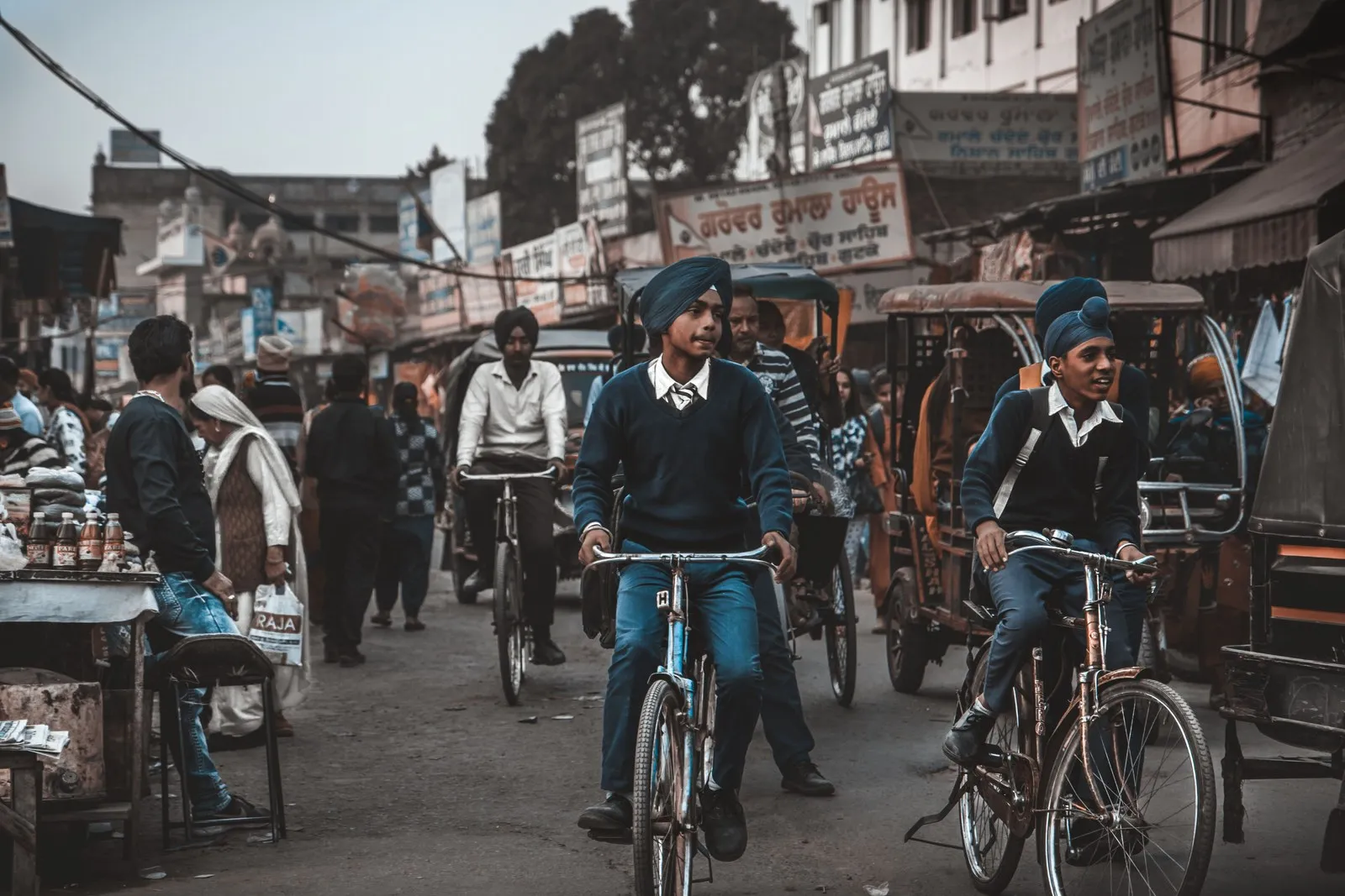 Boys cycling through a busy market street in Amritsar
